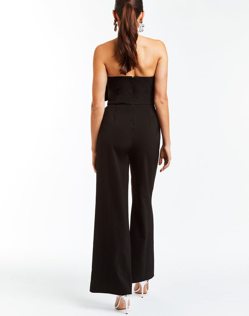 Black stretch crepe jumpsuit with wide legs, sweetheart neckline, and an oversized velvet bow on the front.